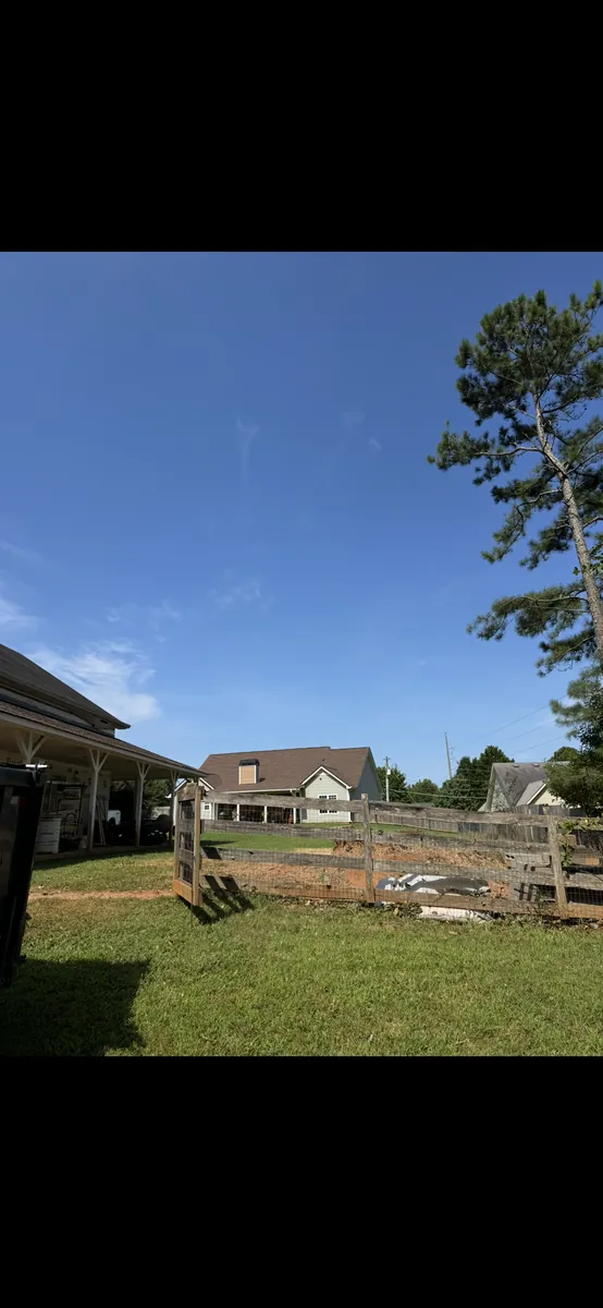 After: five oak trees removed near barn and fence in Holly Springs, GA